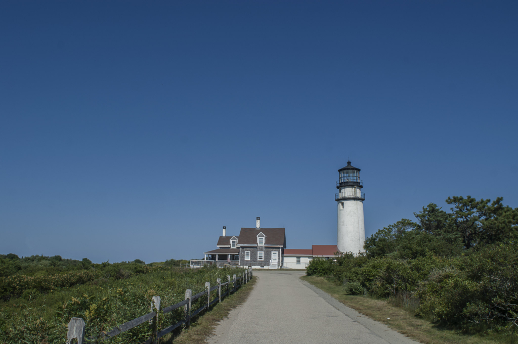 Highland Lighthouse in Truro, MA with surrounding greenery and open landscape