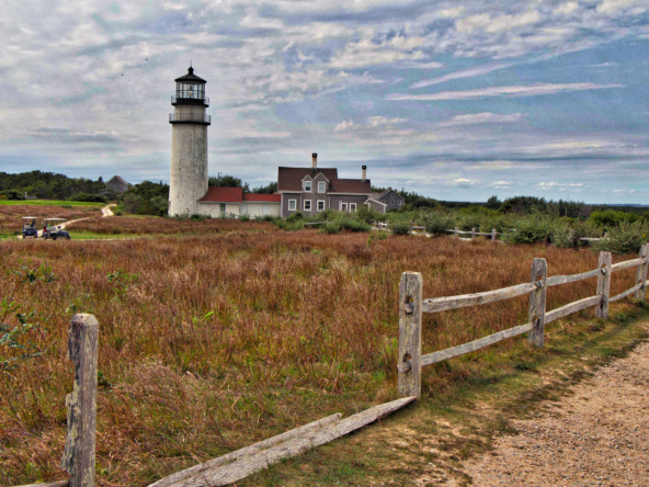 Cape Cod Highland Lighthouse in Truro, MA with clear blue sky and grassy foreground