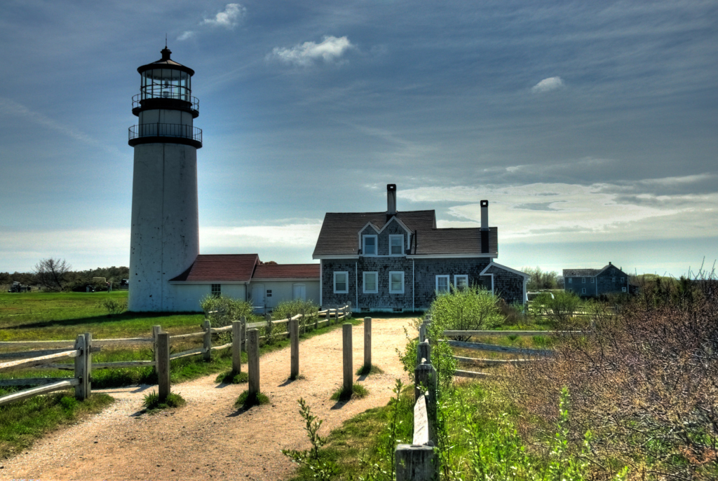 Highland Lighthouse in Truro, Cape Cod, surrounded by open sky and grassy landscape