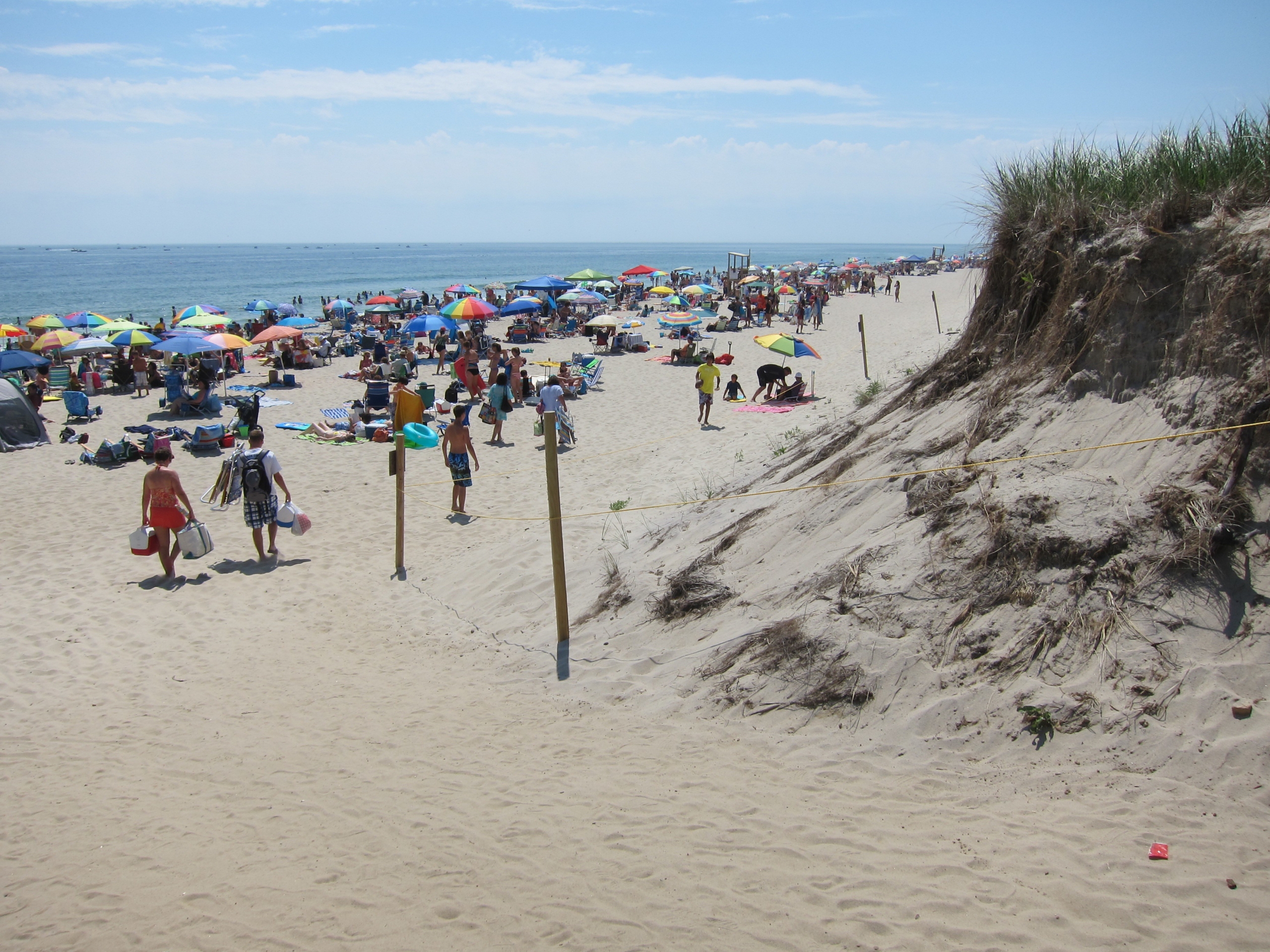 View of Nauset Beach with waves gently crashing onto the shore under a clear sky.