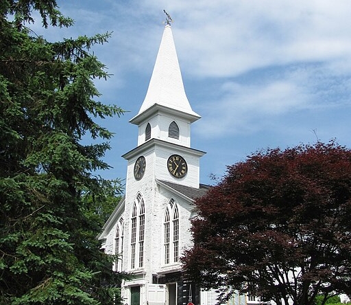 Classic white New England church building with steeple in Brewster, MA