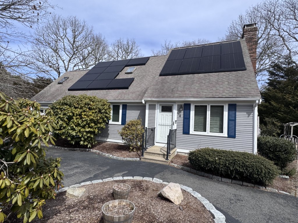 Final walk-through Massachusetts: gray Cape-style home with solar panels and a paved driveway before closing
